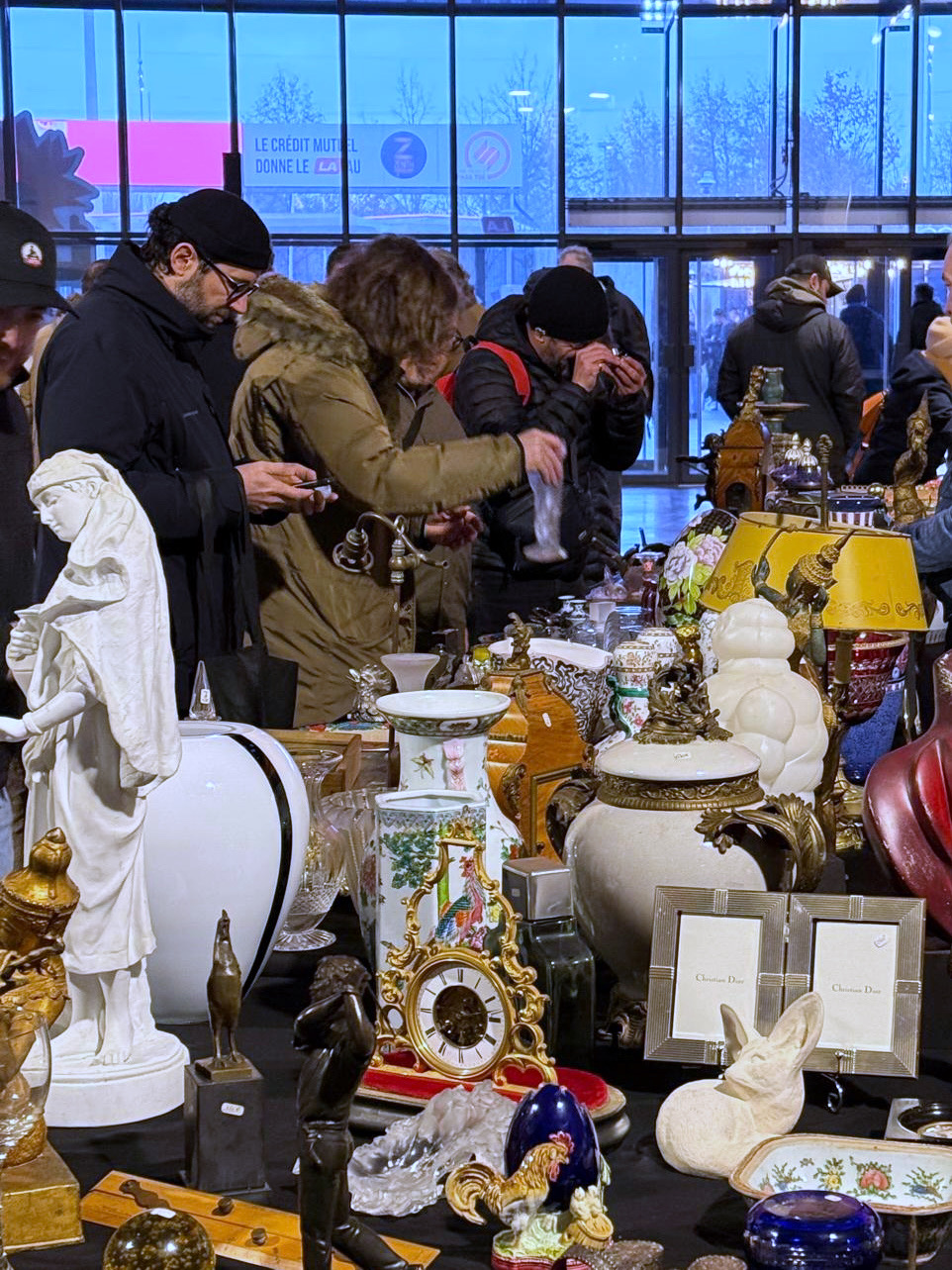 Échange entre exposants et visiteurs au marché d’antiquités de Strasbourg.